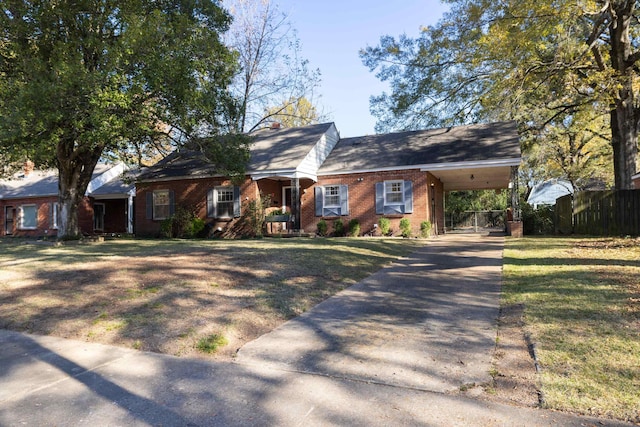 view of front of property with brick siding, concrete driveway, fence, a carport, and a front lawn