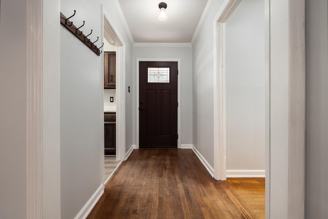 doorway featuring dark wood-style floors, baseboards, and crown molding