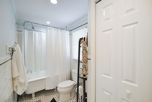 bathroom featuring tile walls, shower / bath combination with curtain, toilet, wainscoting, and tile patterned flooring