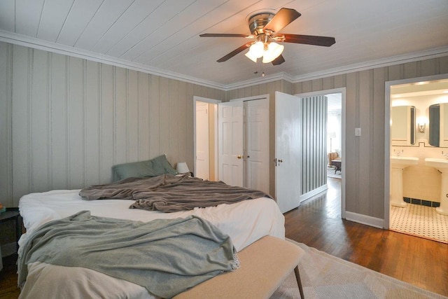 bedroom featuring ceiling fan, wood finished floors, ensuite bathroom, crown molding, and a closet