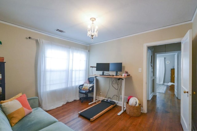 workout room with a notable chandelier, wood finished floors, visible vents, baseboards, and crown molding