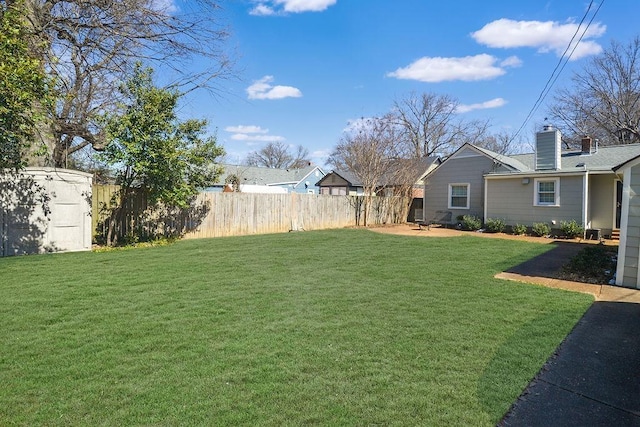 view of yard featuring an outbuilding, a storage unit, a patio area, and fence