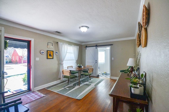 dining area with wood finished floors, baseboards, and a barn door