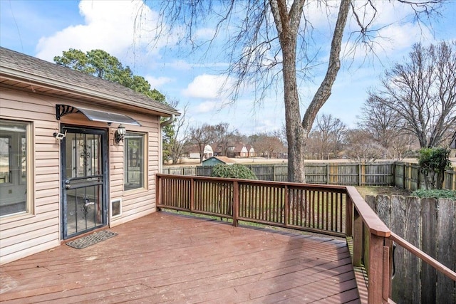 wooden deck with a fenced backyard