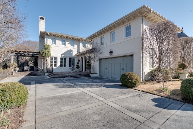 italianate home with a garage, driveway, a chimney, and a pergola