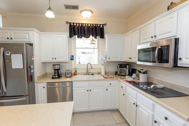 kitchen featuring stainless steel appliances, visible vents, a sink, and ornamental molding