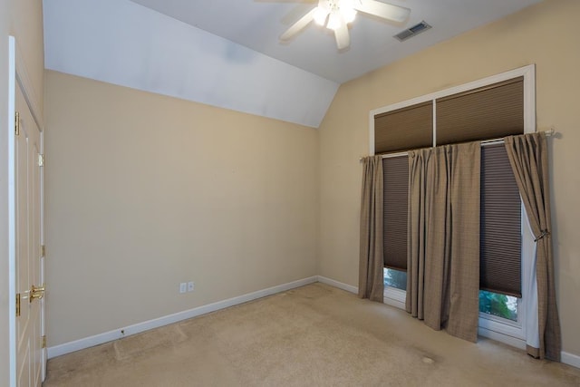 unfurnished bedroom featuring light carpet, visible vents, baseboards, a ceiling fan, and vaulted ceiling