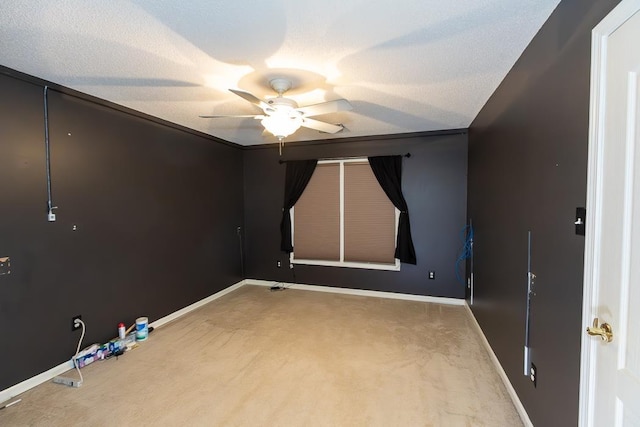 empty room with carpet, ceiling fan, a textured ceiling, and baseboards