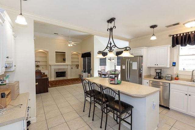 kitchen featuring a fireplace, stainless steel appliances, visible vents, open floor plan, and a sink