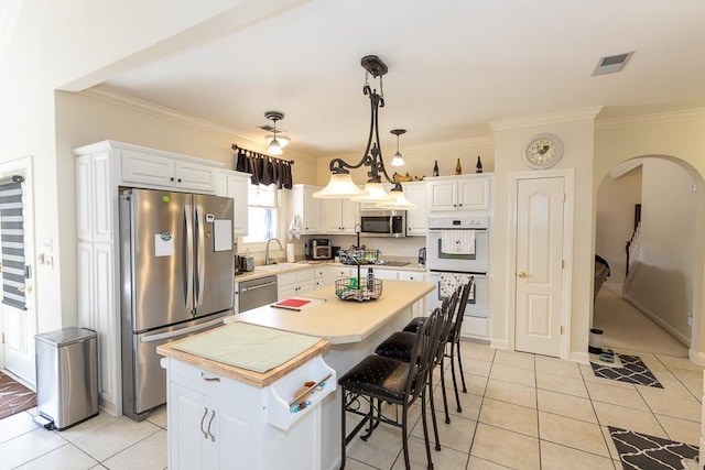 kitchen featuring stainless steel appliances, a sink, white cabinets, and a center island