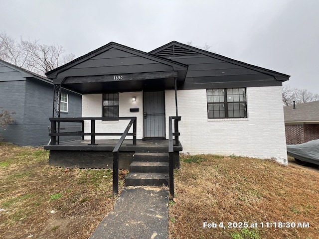 view of front of home featuring covered porch and brick siding