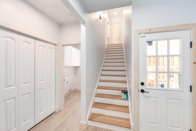 stairway featuring a wealth of natural light, baseboards, and wood finished floors