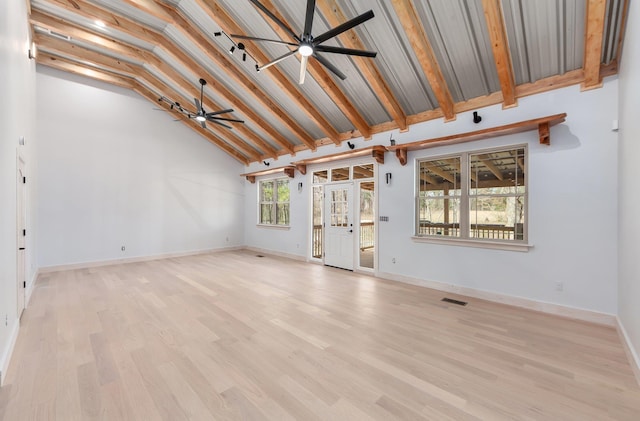 unfurnished living room with baseboards, ceiling fan, beam ceiling, and light wood-style floors