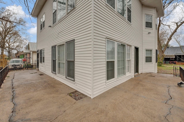 view of side of property featuring a patio and fence