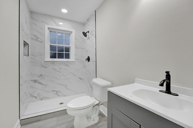 full bathroom with toilet, recessed lighting, vanity, baseboards, and a marble finish shower