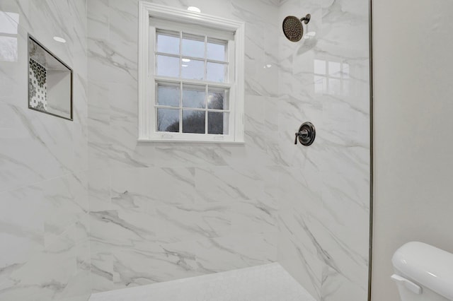 bathroom featuring toilet and a marble finish shower