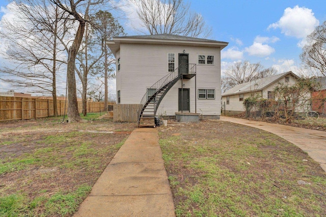 traditional home featuring fence and stairs