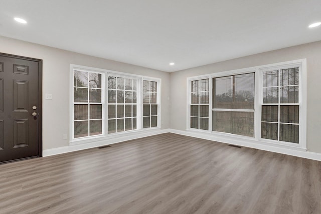 interior space featuring recessed lighting, wood finished floors, visible vents, and baseboards