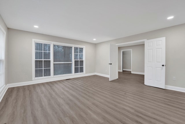 unfurnished room featuring recessed lighting, baseboards, and wood finished floors