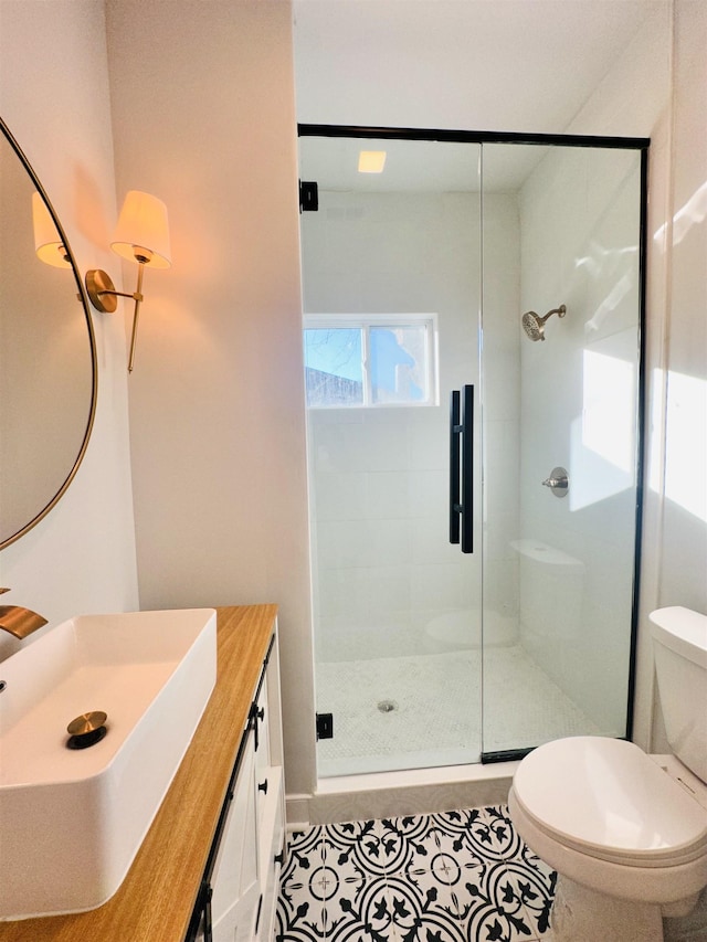 bathroom with toilet, a stall shower, tile patterned flooring, and vanity