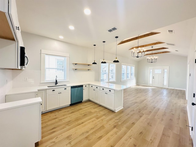 kitchen featuring light wood finished floors, visible vents, appliances with stainless steel finishes, a sink, and a peninsula