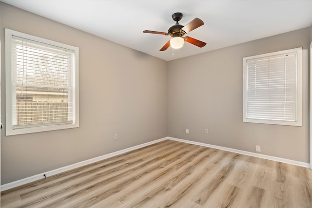 unfurnished room with light wood-type flooring, a ceiling fan, and baseboards