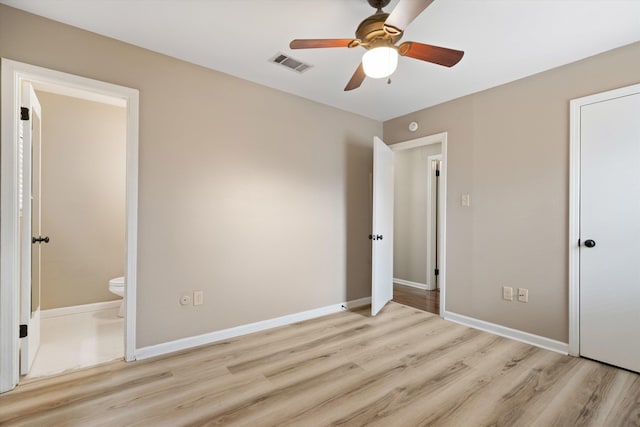 unfurnished bedroom with connected bathroom, a ceiling fan, visible vents, baseboards, and light wood finished floors