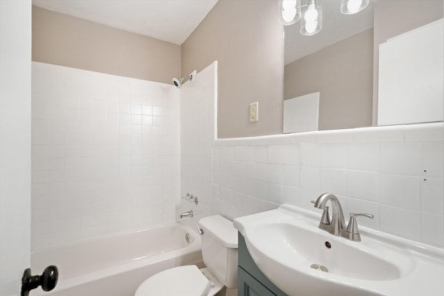 bathroom with vanity, shower / tub combination, toilet, and tile walls