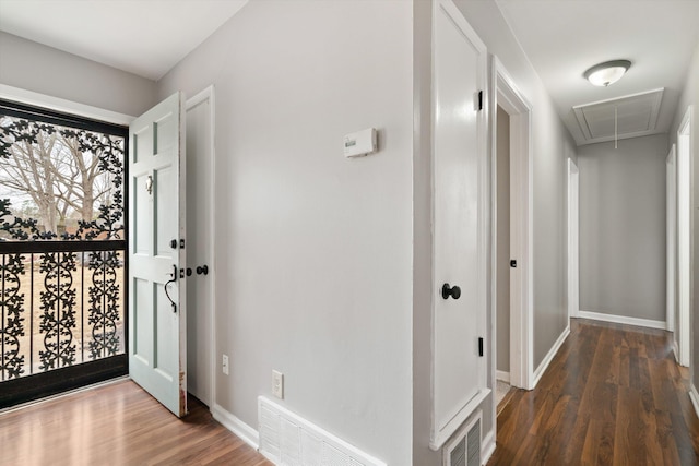 foyer entrance featuring baseboards, visible vents, and wood finished floors