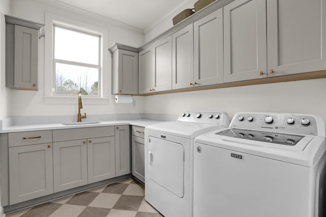 washroom featuring light floors, cabinet space, ornamental molding, washing machine and dryer, and a sink