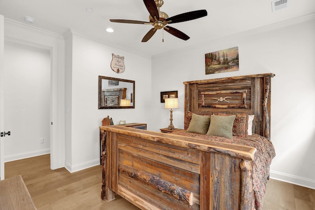 bedroom with baseboards, visible vents, a ceiling fan, wood finished floors, and crown molding