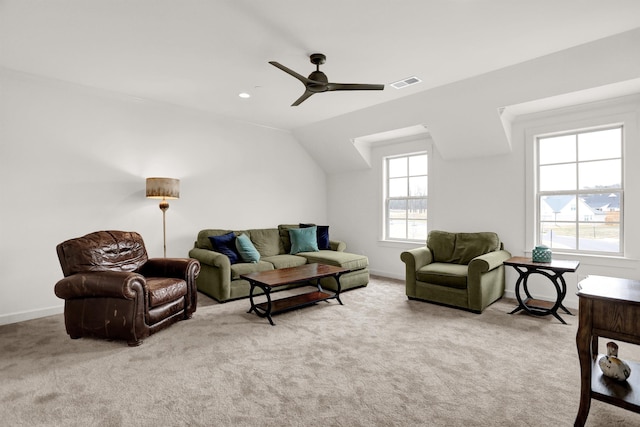 carpeted living area with a ceiling fan, visible vents, plenty of natural light, and baseboards