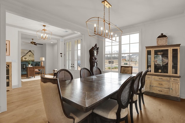 dining area featuring crown molding, light wood-style floors, and a notable chandelier