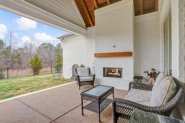 view of patio with an outdoor brick fireplace and fence