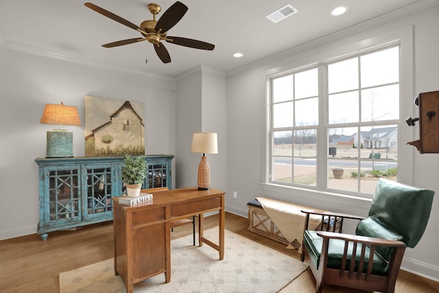 office space with light wood finished floors, ornamental molding, and visible vents