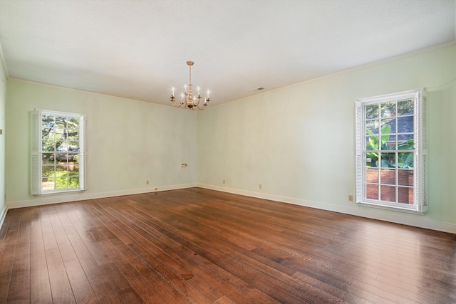 empty room with a chandelier, baseboards, and dark wood-style floors