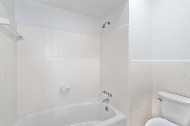 full bath featuring toilet, a wainscoted wall, tile walls, and shower / bathtub combination