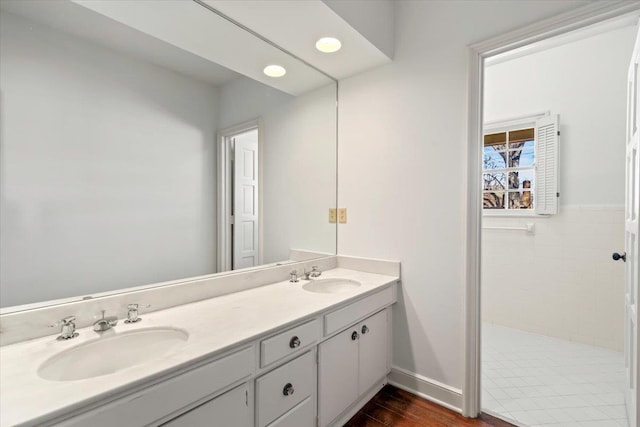 full bath with wood finished floors, a sink, and double vanity