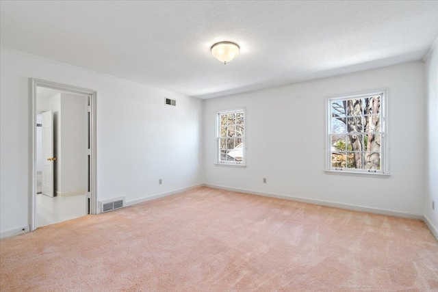 spare room with baseboards, visible vents, a textured ceiling, and carpet flooring