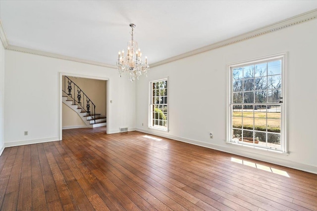 unfurnished room featuring baseboards, visible vents, hardwood / wood-style flooring, stairway, and crown molding