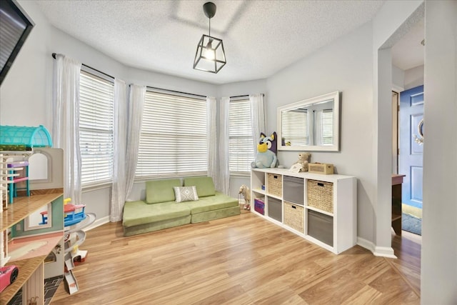 sitting room with a textured ceiling, plenty of natural light, and light wood-style flooring