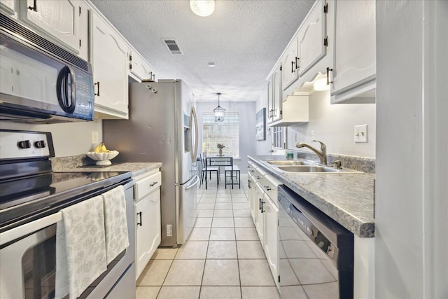 kitchen featuring electric range, visible vents, dishwashing machine, black microwave, and a sink