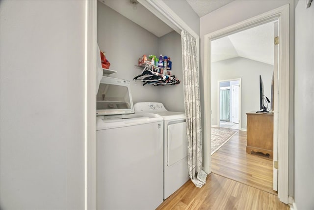 washroom featuring light wood-type flooring, laundry area, and washing machine and clothes dryer