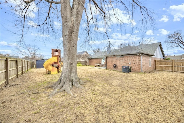 view of yard featuring a playground, a fenced backyard, and cooling unit