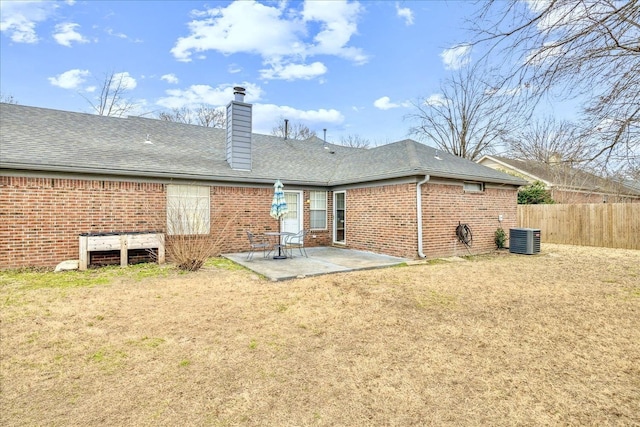 rear view of house featuring a patio area, brick siding, and fence