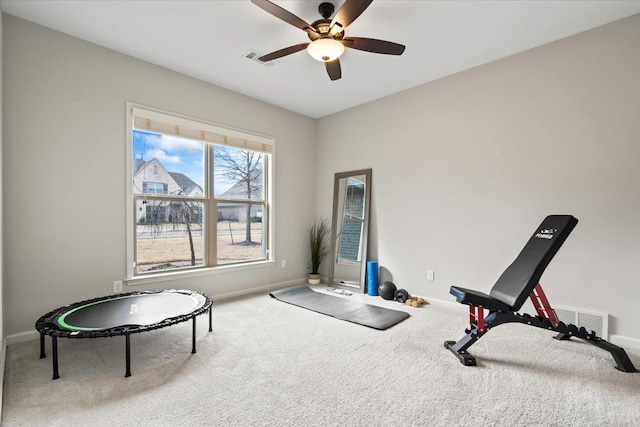 workout room featuring carpet floors, visible vents, baseboards, and a ceiling fan