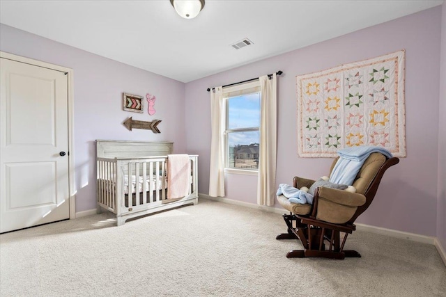 carpeted bedroom featuring a crib, visible vents, and baseboards