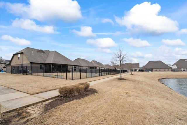 surrounding community featuring a water view, a residential view, and fence