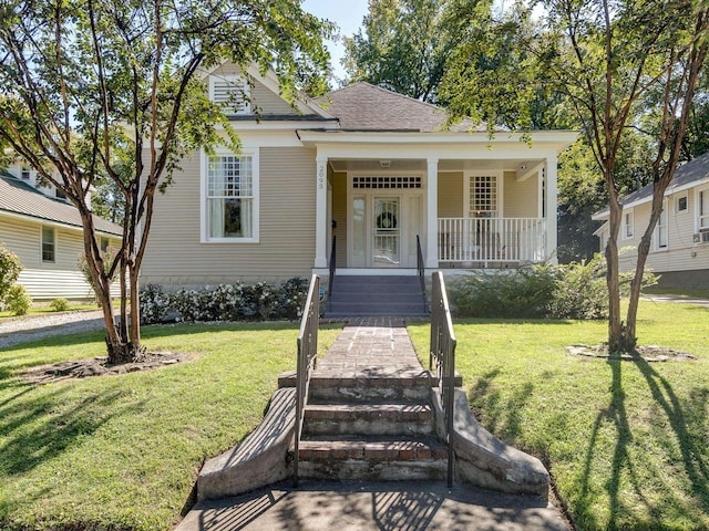 view of front of property with a front lawn, roof with shingles, and a porch