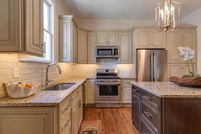 kitchen featuring cream cabinetry, appliances with stainless steel finishes, dark wood-type flooring, ornamental molding, and a sink